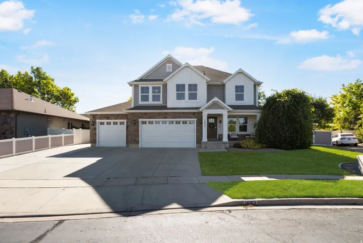 Stately two-story residence featuring a combination of brick and siding, a three-car garage, and a manicured front lawn