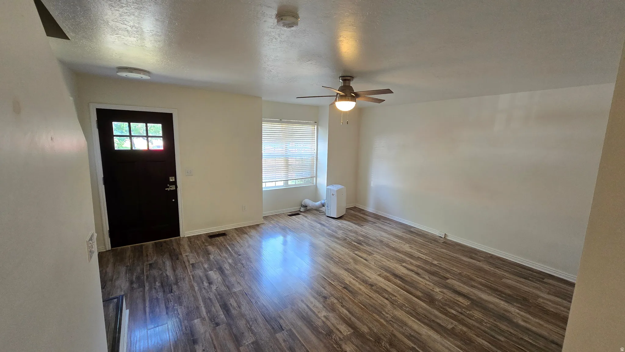 Wood-finish flooring throughout, complemented by a ceiling fan with integrated lighting