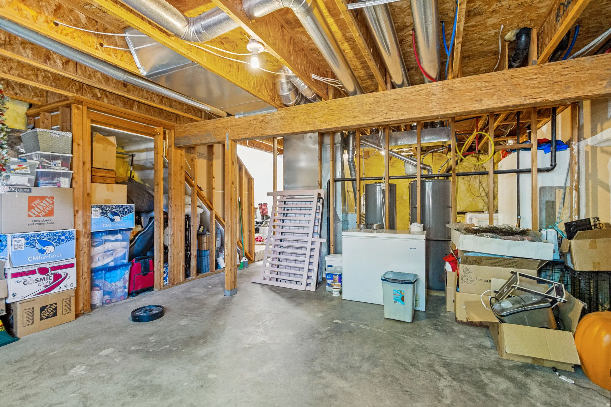 Unfinished basement featuring exposed wood framing, concrete flooring, and visible ductwork