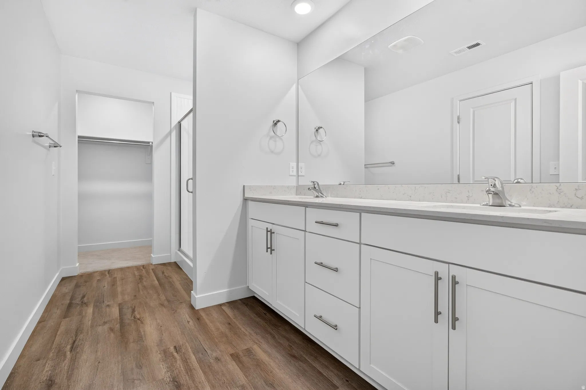 Bathroom featuring a double vanity with white cabinetry and light-toned countertops