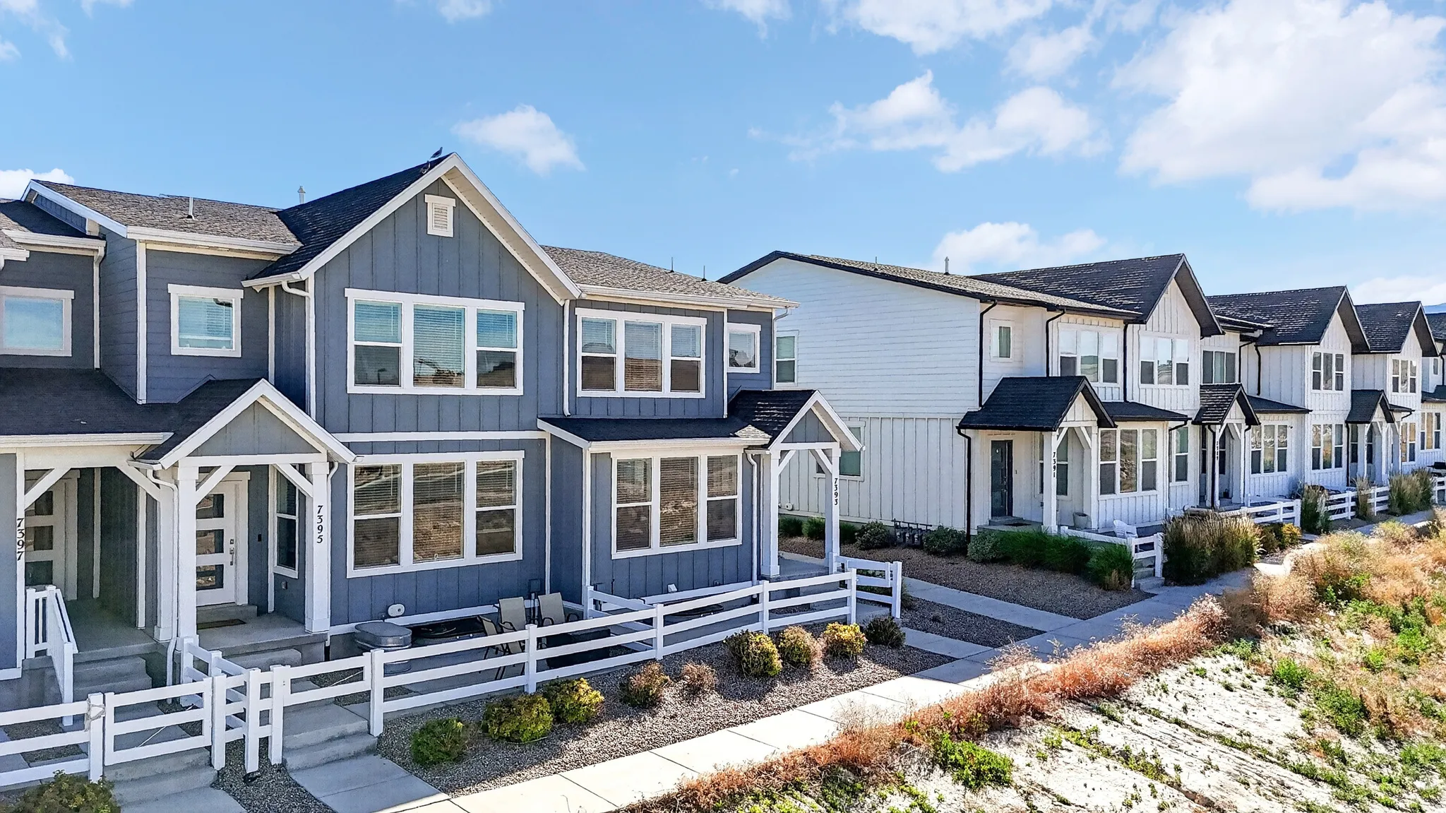 Modern townhome exterior featuring blue siding and white trim
