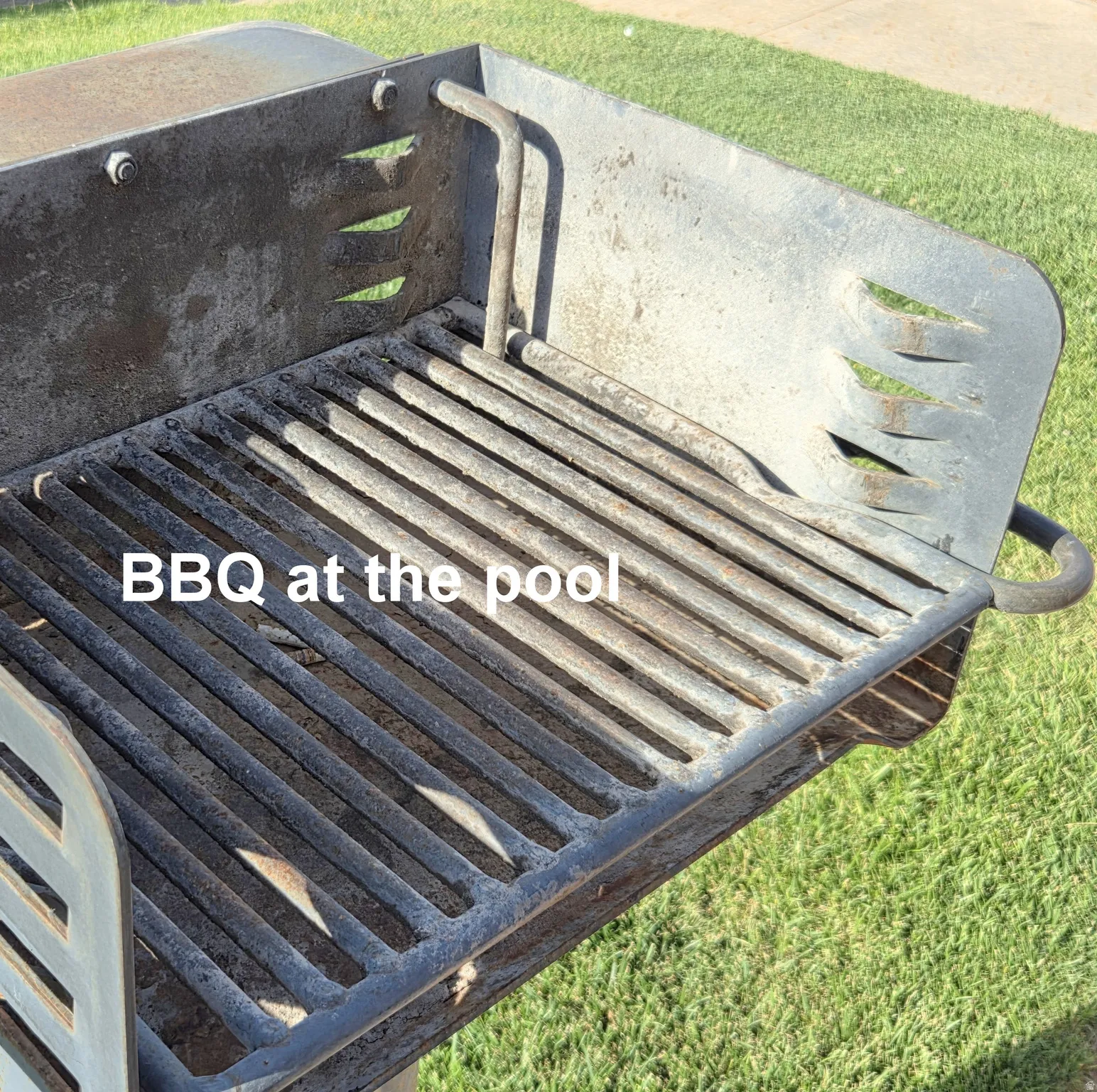 Built-in outdoor grill with a metal grate cooking surface, supported by a sturdy metal frame