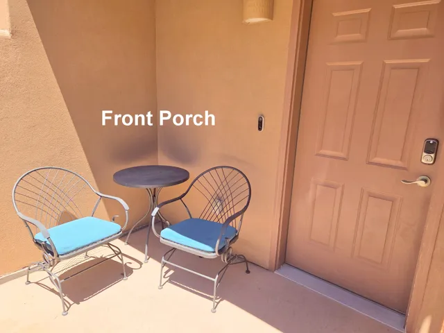 Entry porch featuring a panel door, stucco exterior, and wall-mounted light fixture