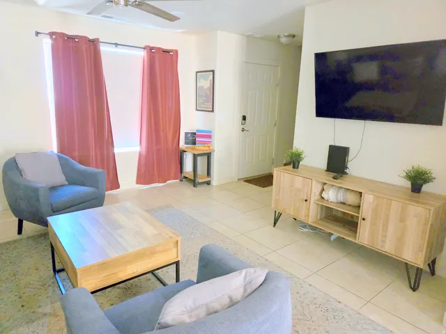 Open concept living area featuring tile flooring, a ceiling fan, and a prominent window
