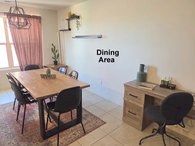 Dining area featuring a contemporary linear chandelier, tiled flooring, and a window with natural light