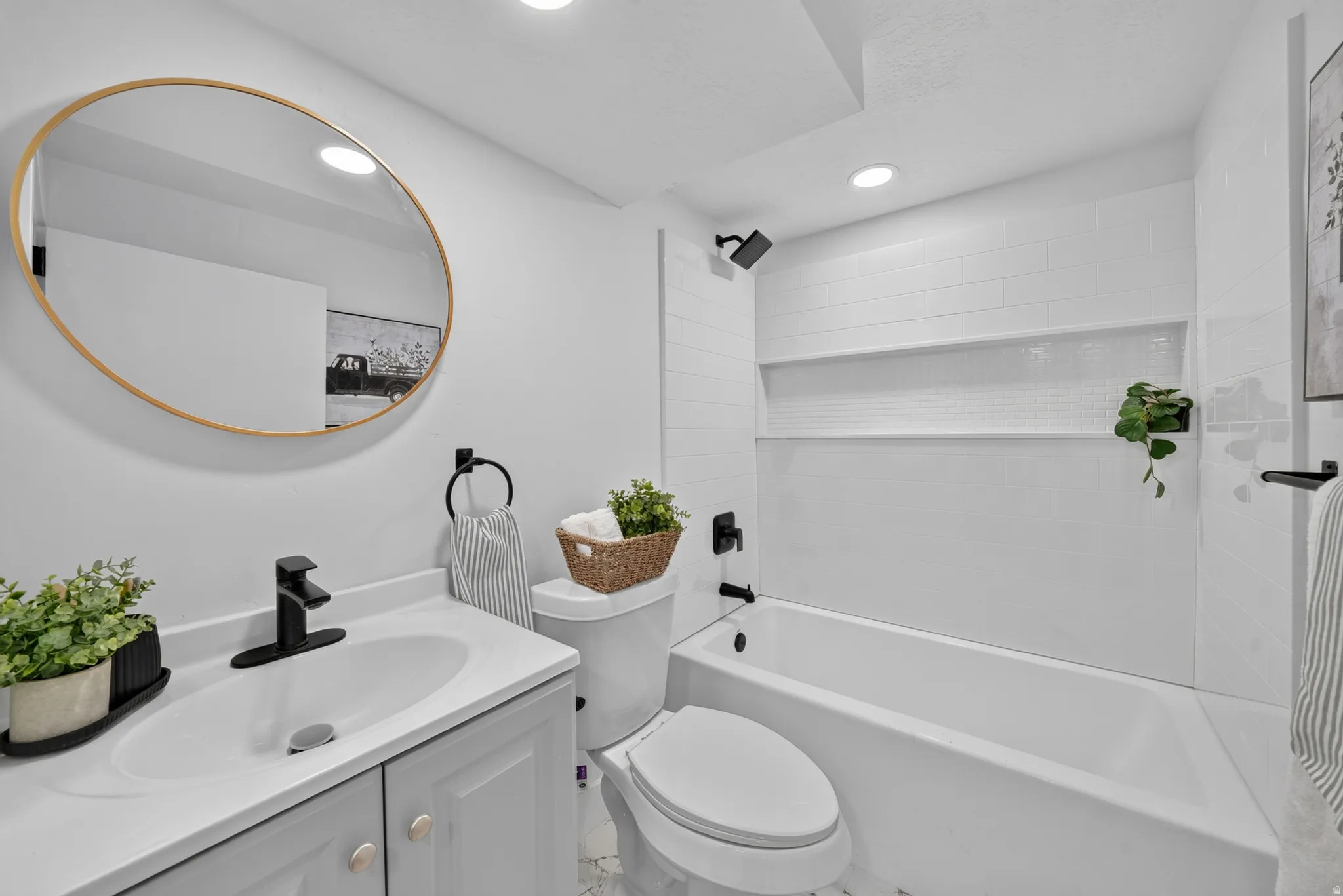 Bathroom featuring a white vanity with gray cabinetry, a rectangular undermount sink, and a matte black faucet