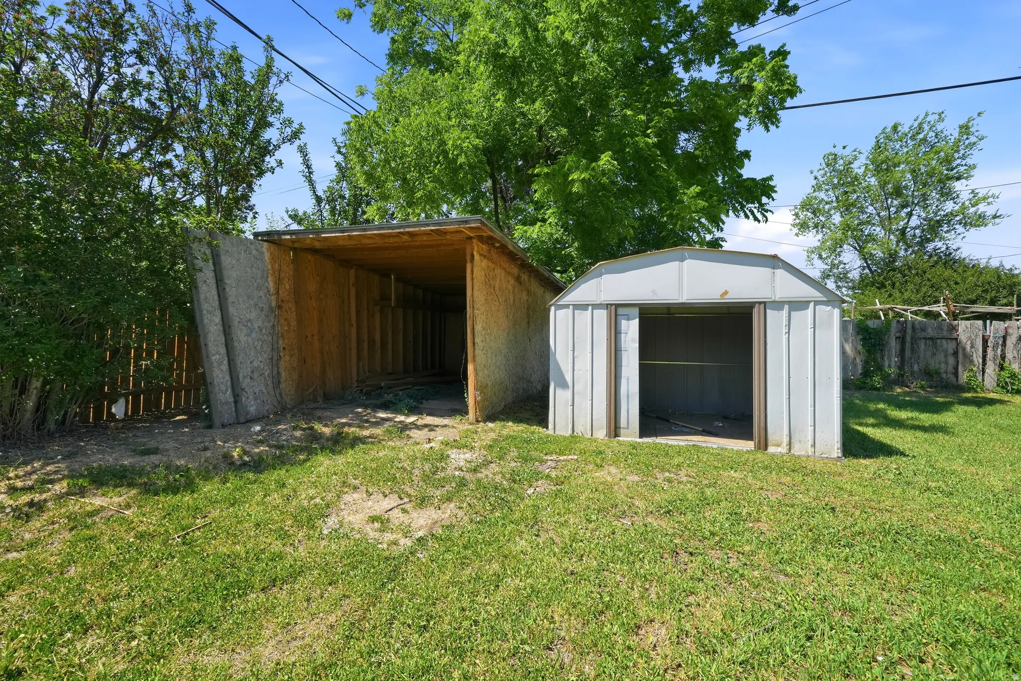 Expansive backyard featuring a shed and an open-sided storage structure