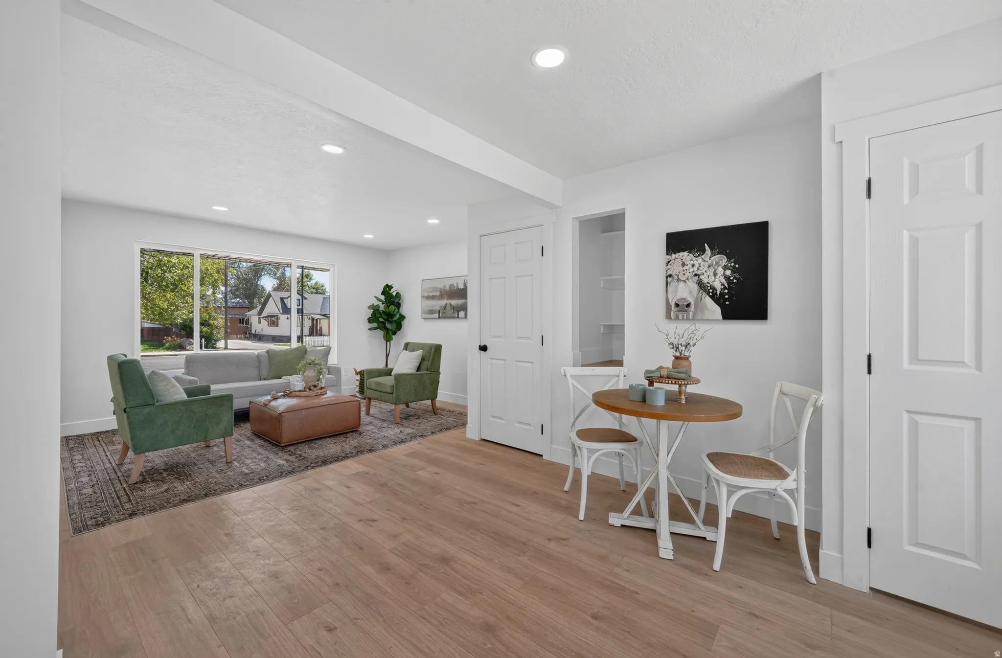 Open-concept living space featuring wood-finish flooring, recessed lighting, and a neutral color palette