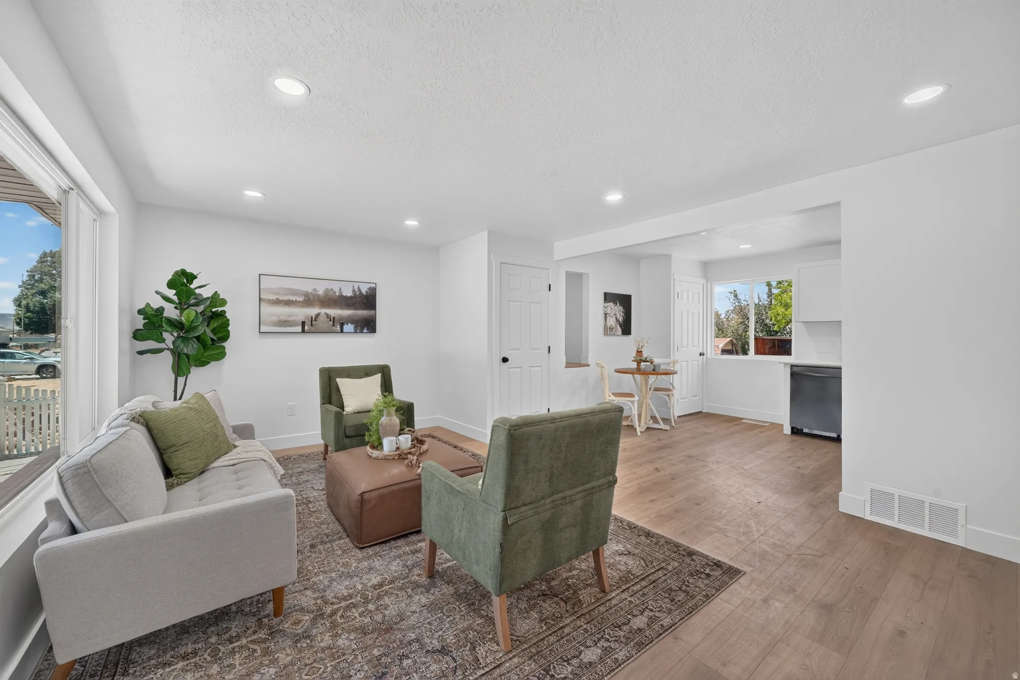 Open concept living area featuring wood-finish flooring, recessed lighting, and white walls
