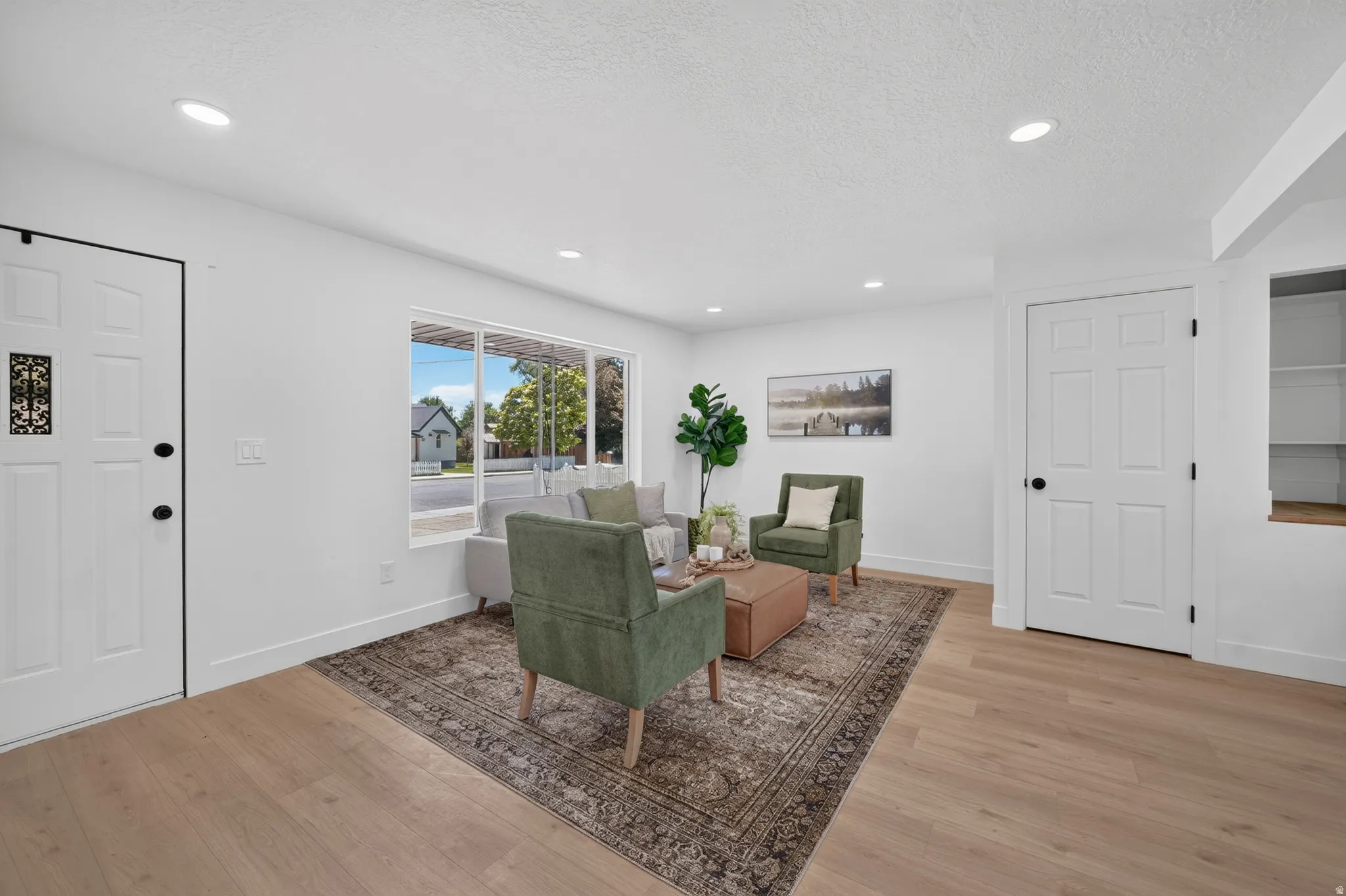 Bright living area with wide plank wood-finish flooring