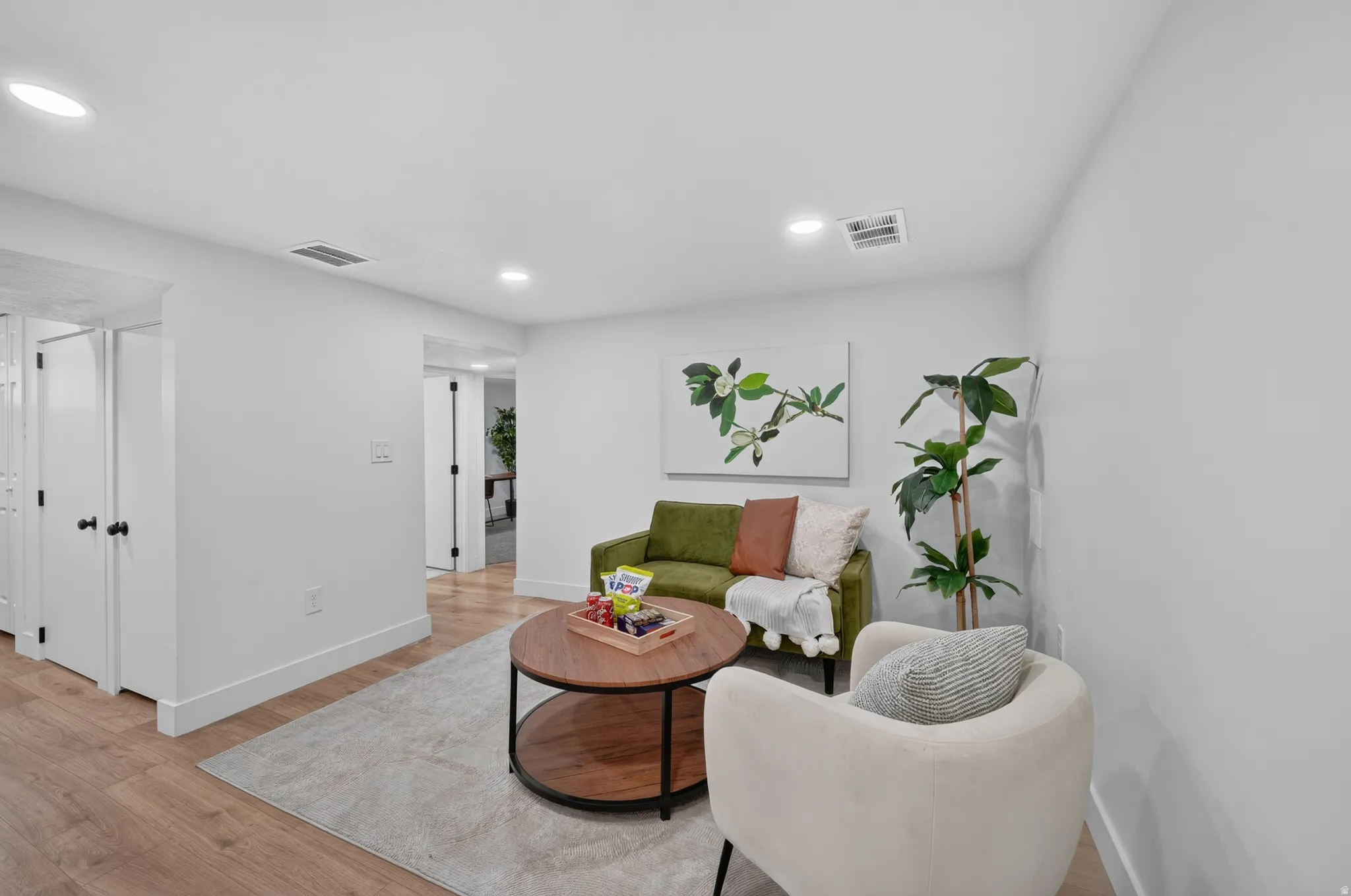 Light wood-finish flooring complements crisp white walls in this interior space