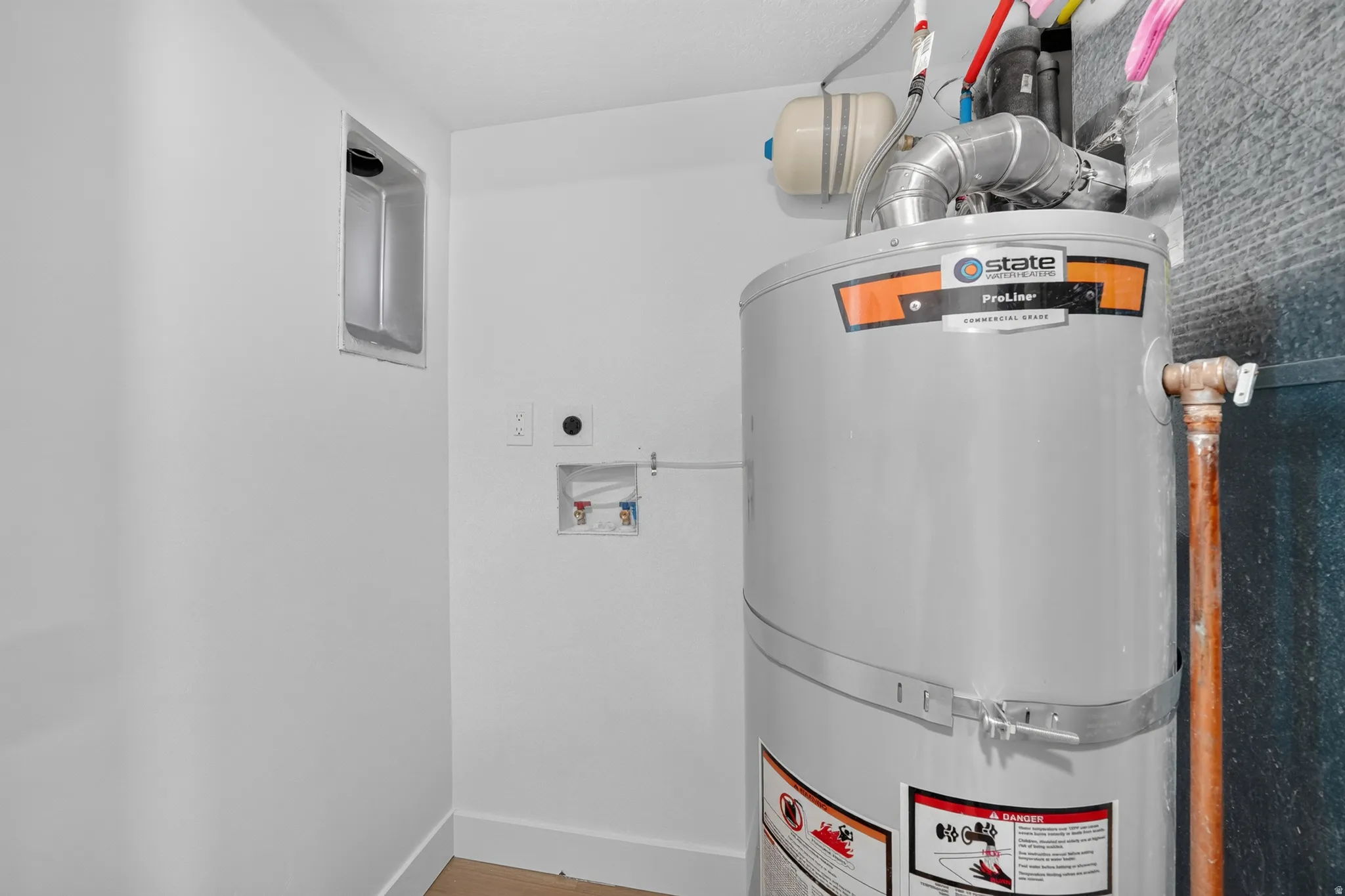 Dedicated utility area featuring a water heater, laundry hookups, and a wall vent