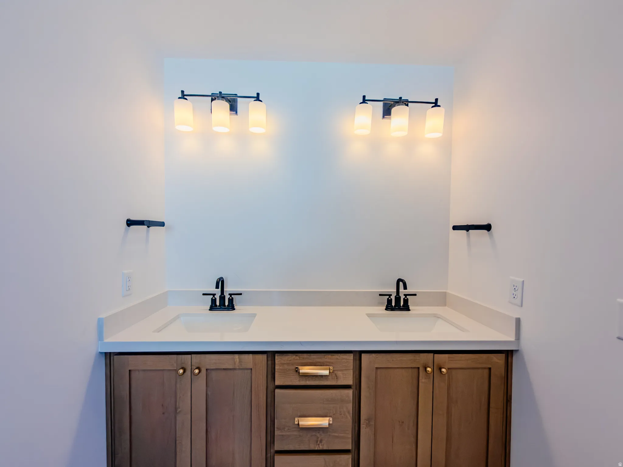 Dual wood-finish vanities with light countertops and rectangular undermount sinks