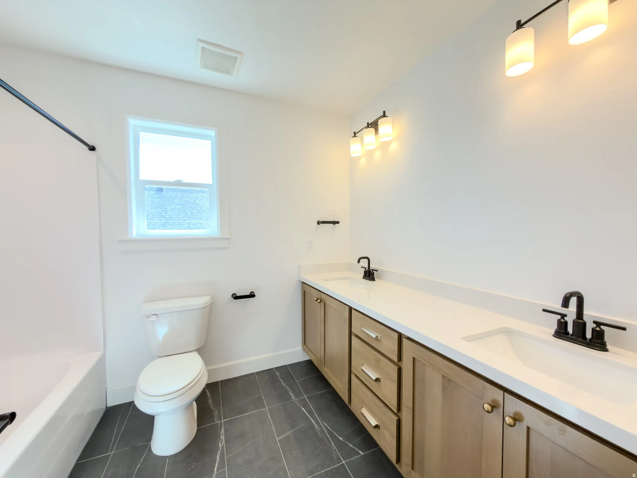 Double vanity with white countertops, undermount sinks, and matte black fixtures