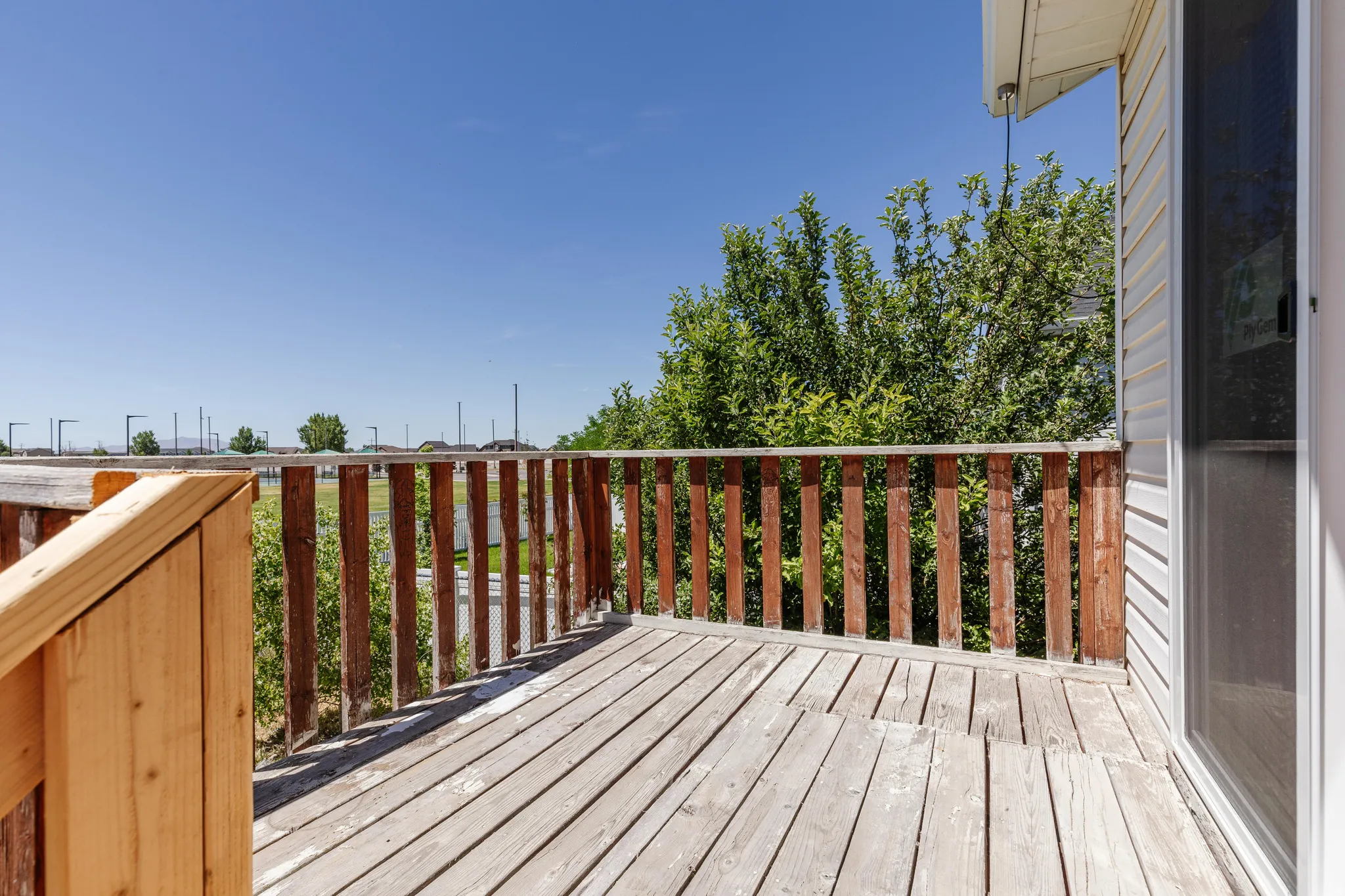Outdoor wood deck with a natural wood railing, offering exterior access to the property