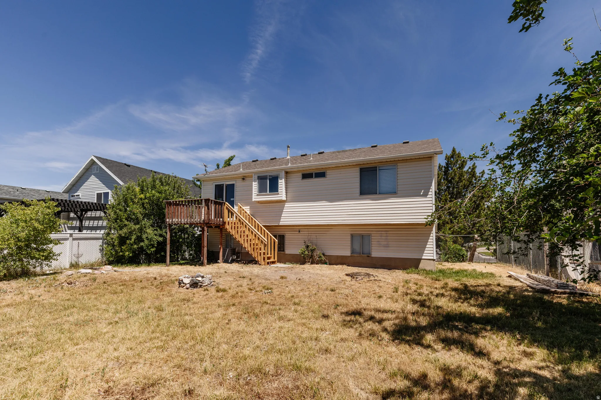 Rear exterior featuring vinyl siding, a multi-level wood deck, and an upper-level sliding glass door