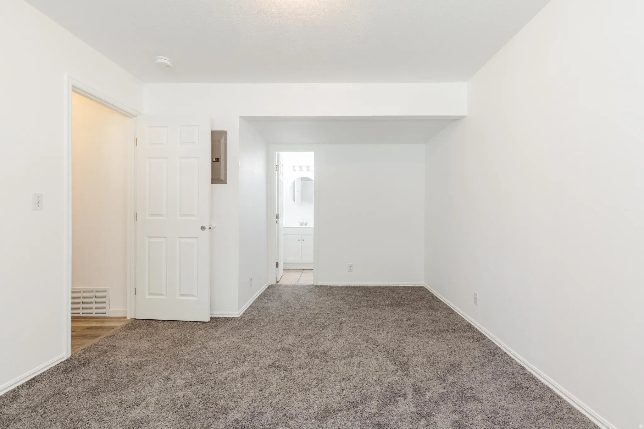 Carpeted interior space with white walls and baseboards