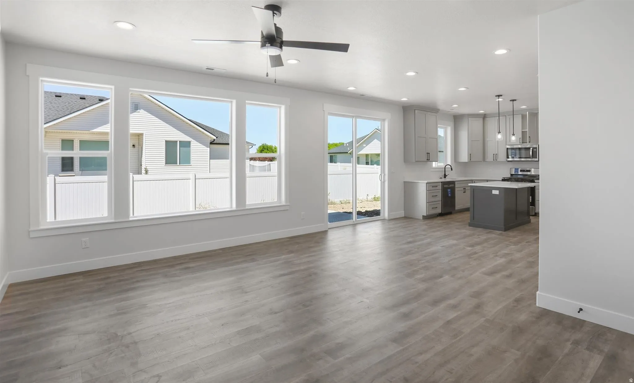Open-concept living space featuring wood-finish flooring, recessed lighting, and a modern ceiling fan