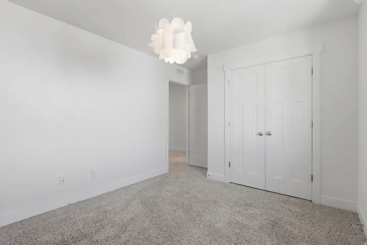 Neutral tone carpeting with white baseboards throughout