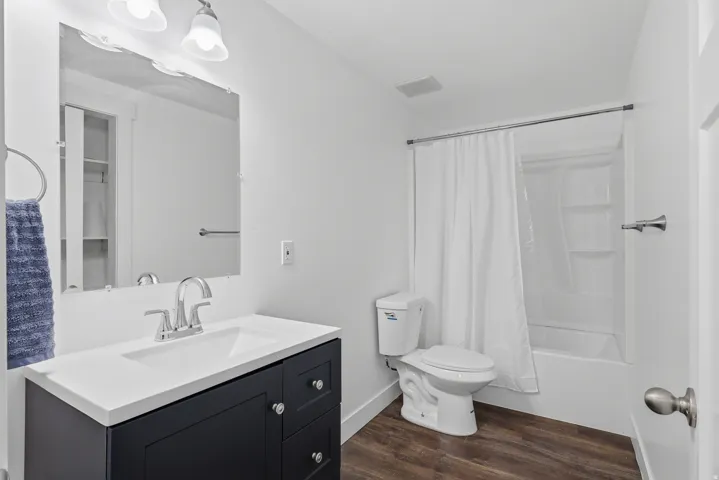 Bathroom featuring a dark wood-finish vanity with an integrated sink, chrome faucet, and a large mirror