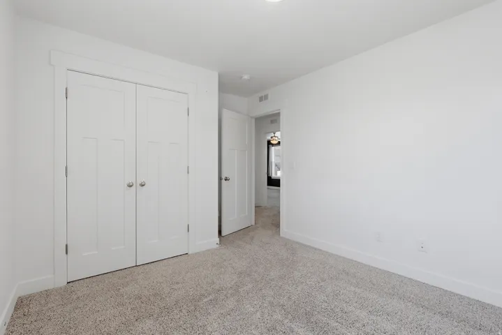 Plush neutral-toned carpet flooring and bright white walls