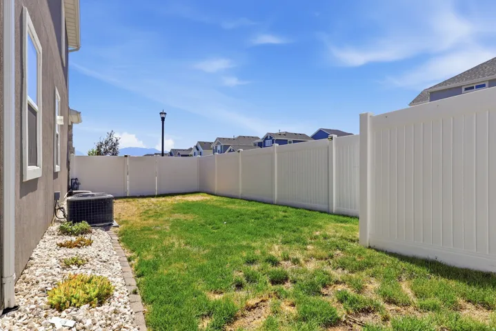 Private backyard featuring a full vinyl privacy fence