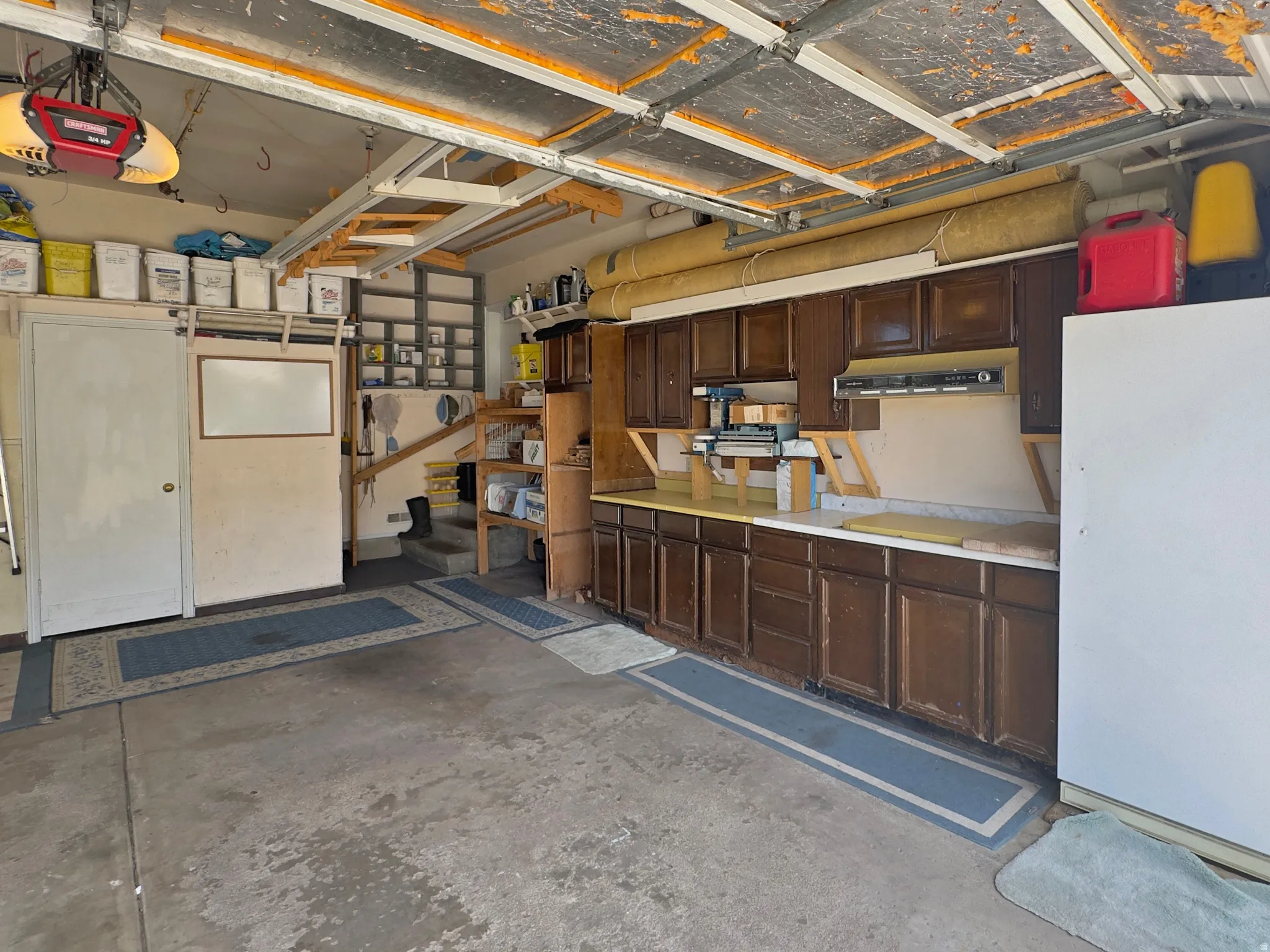 Garage space featuring concrete flooring, built-in cabinetry with dark wood-finish doors, and an integrated workbench surface