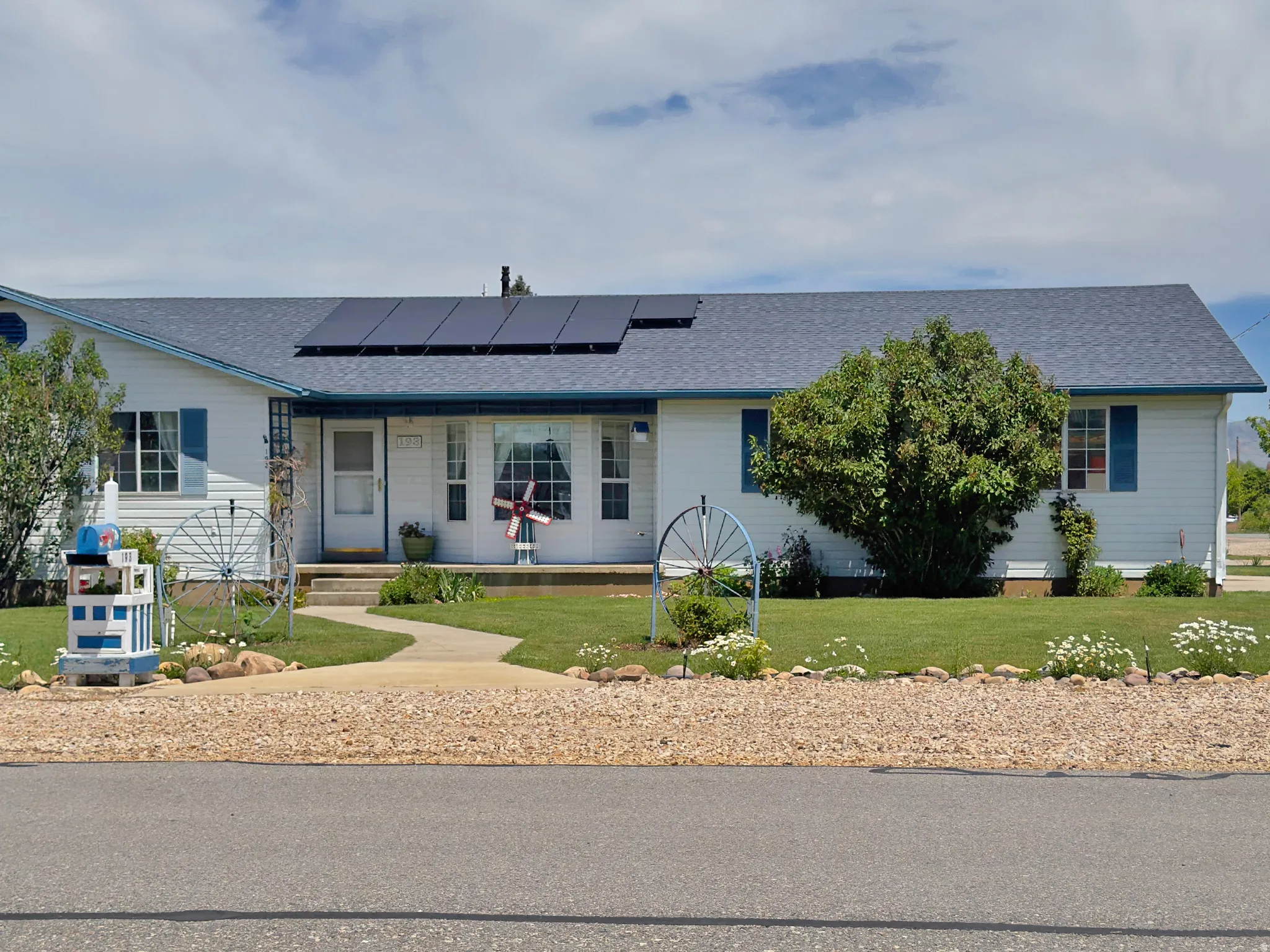 White-sided residence featuring a blue shingle roof and solar panels
