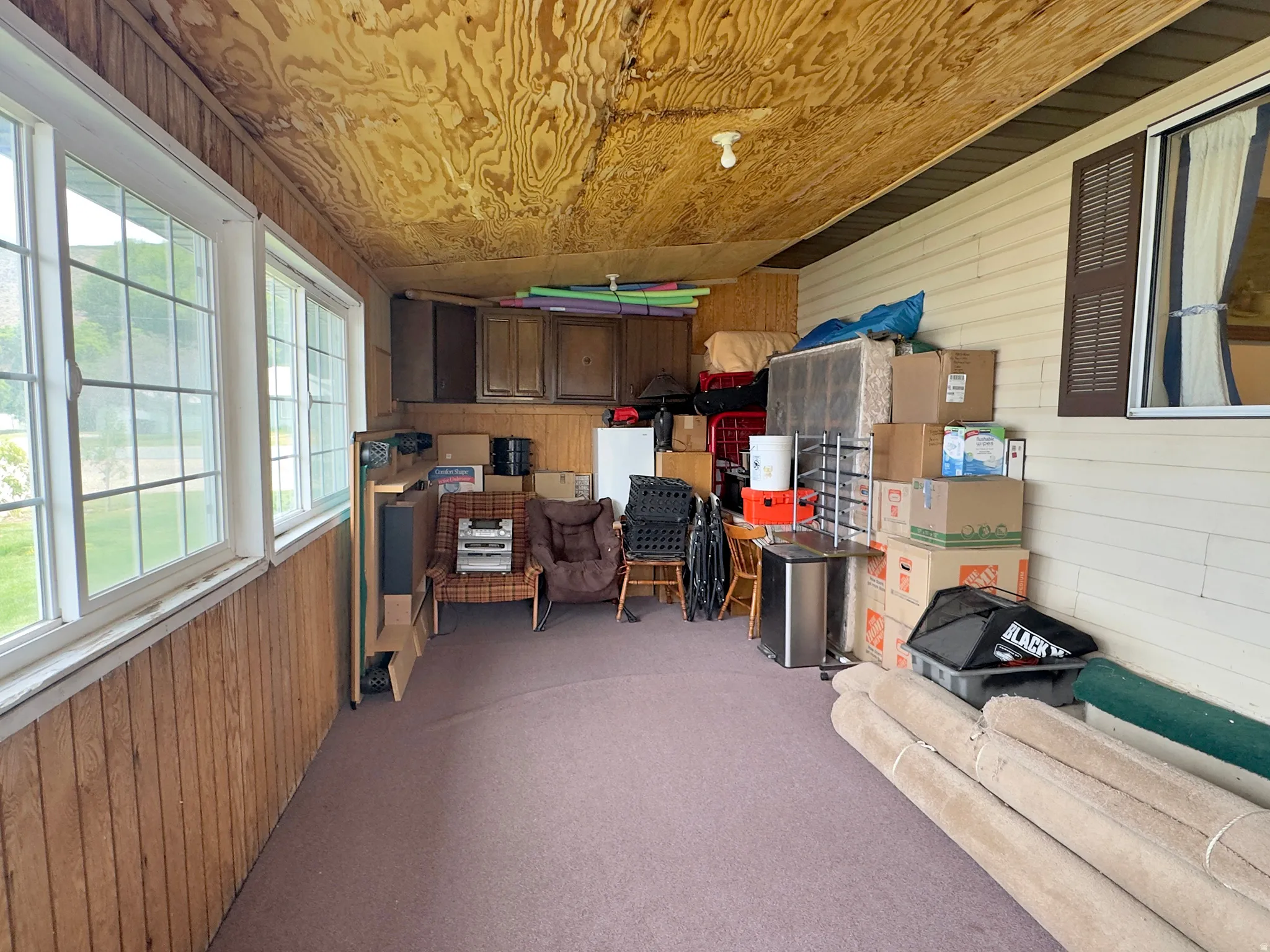 Enclosed porch featuring multiple large windows, wood-paneled walls, and a wood-finish ceiling