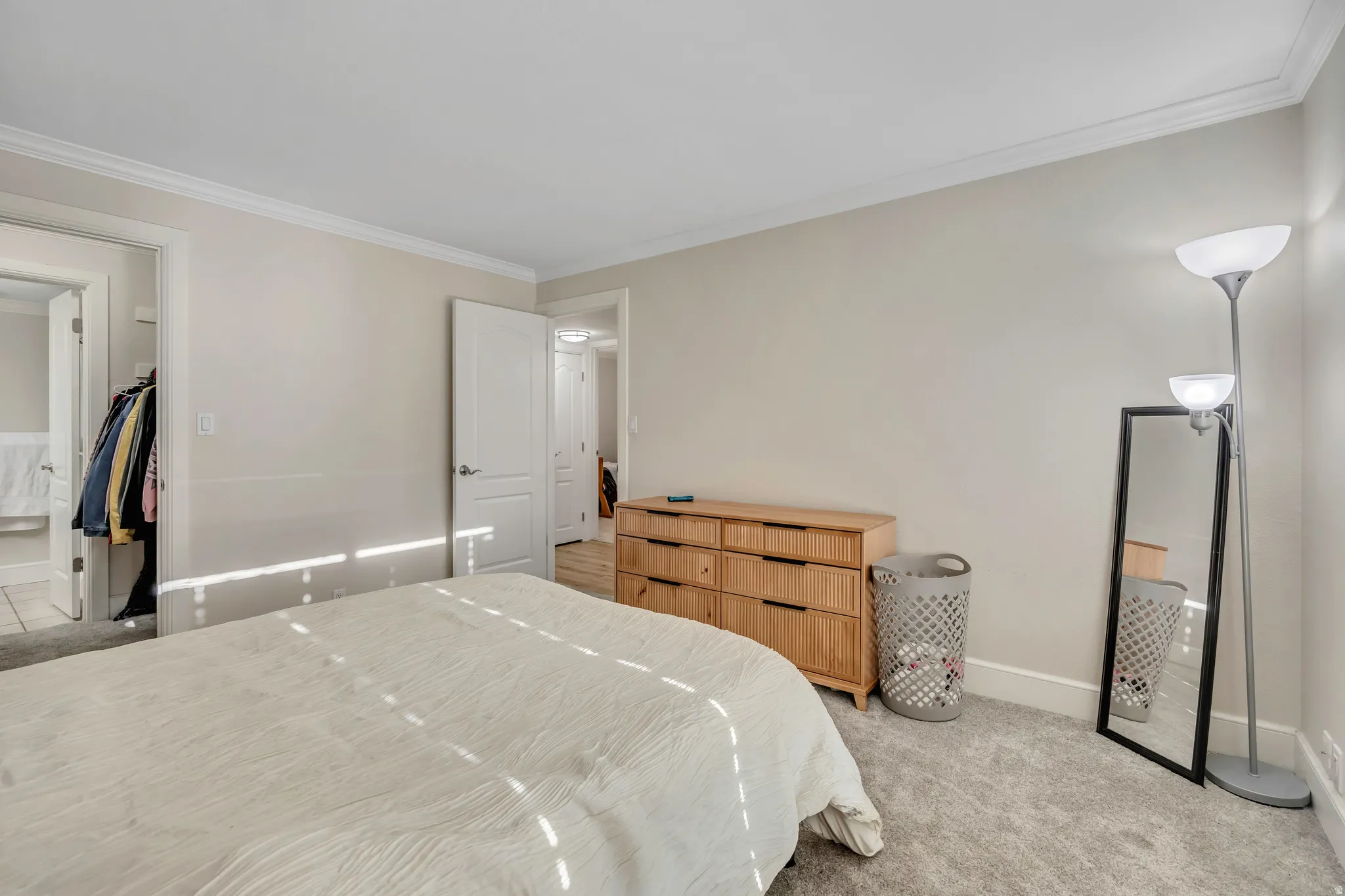 Carpeted bedroom with neutral wall tones and crown molding