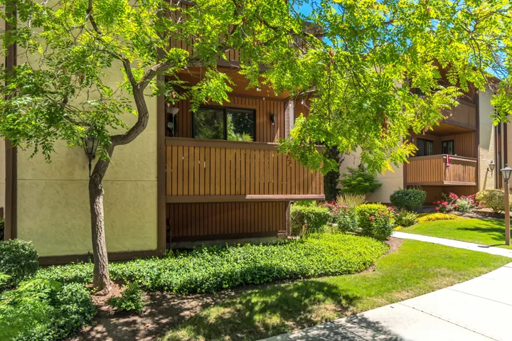 Stucco exterior with brown trim accents and wood-slat balcony railings