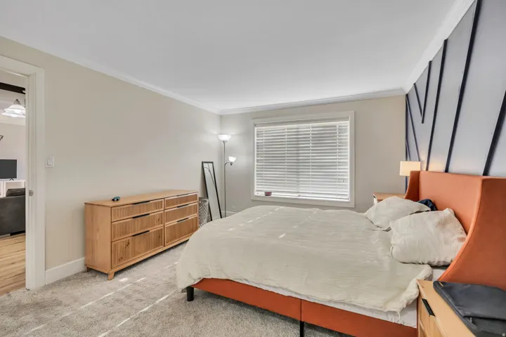 Bedroom featuring neutral wall paint, crown molding, and plush carpet flooring
