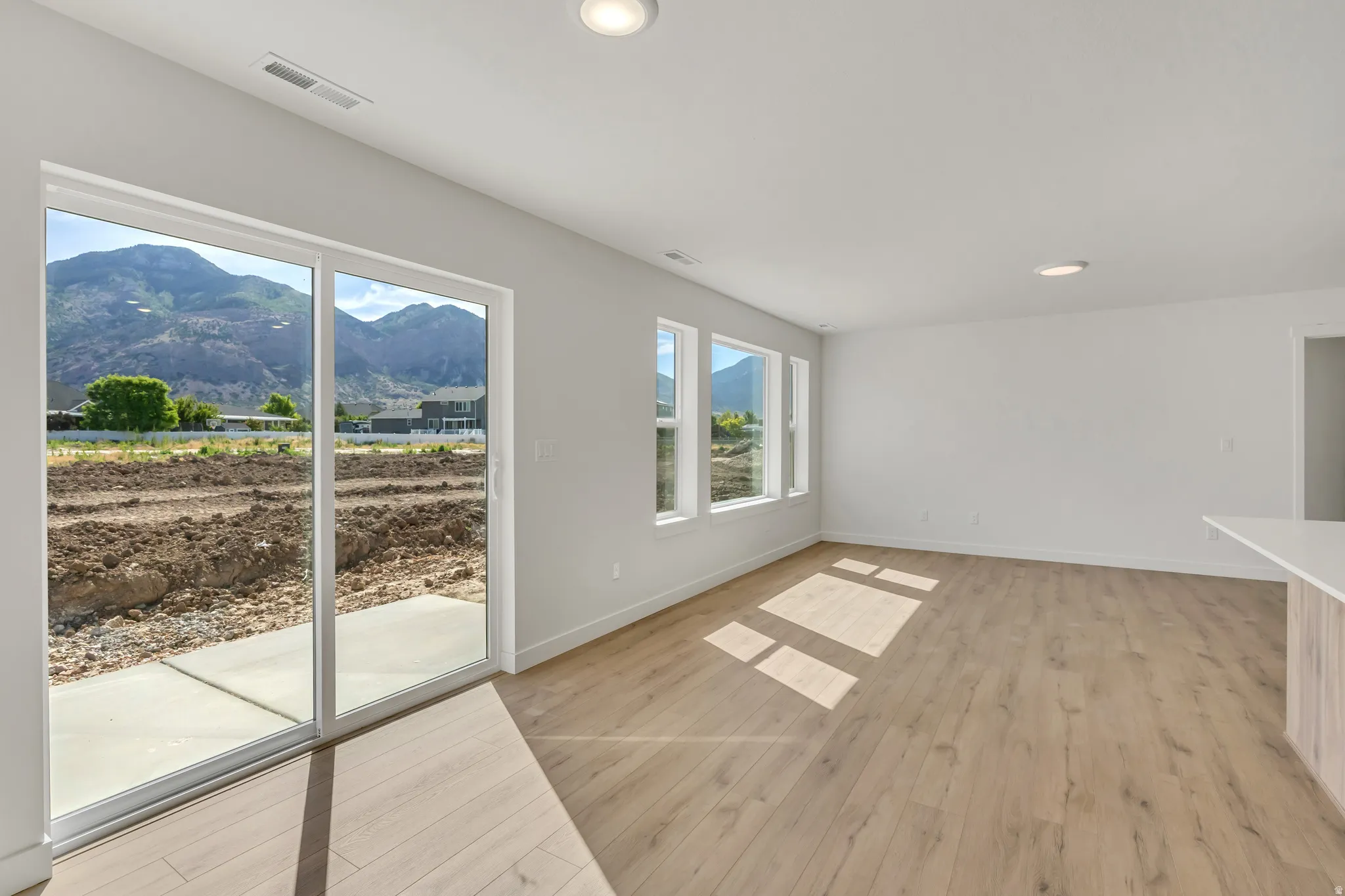 Spacious room featuring wood-finish flooring and recessed ceiling lights