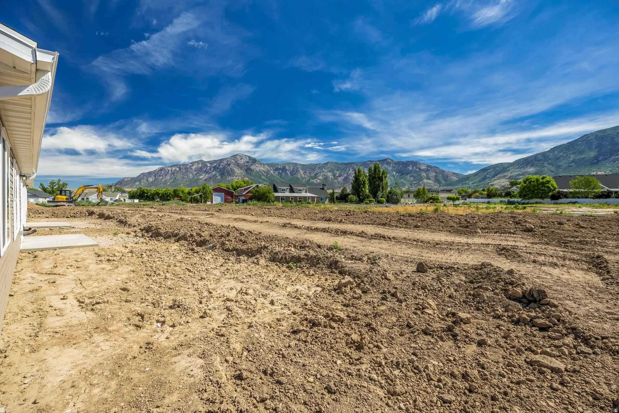 Spacious lot featuring prepared ground for landscaping, a concrete patio foundation, and a mountain backdrop