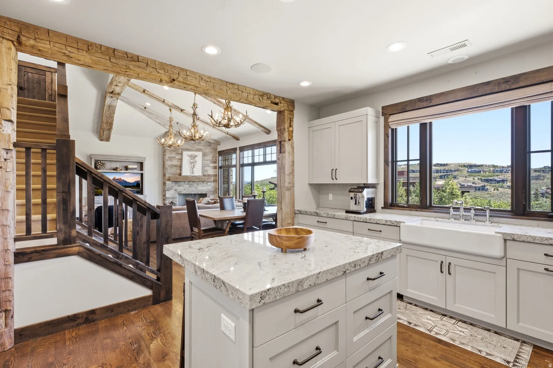 Gourmet kitchen featuring a center island with a quartz countertop, white shaker cabinetry, and a farmhouse sink
