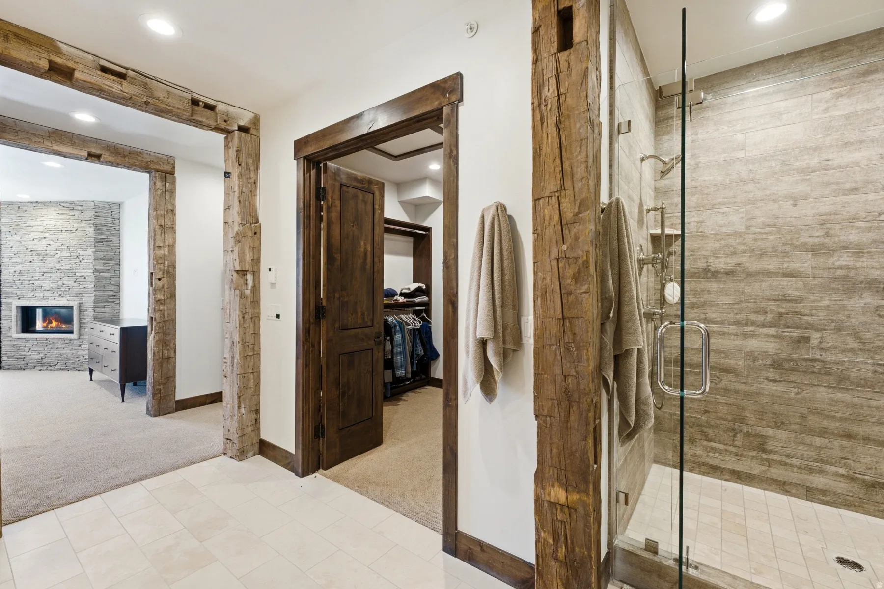 Glass-enclosed shower with subway tile surround and built-in shelving, featuring a rain shower head and separate handheld sprayer
