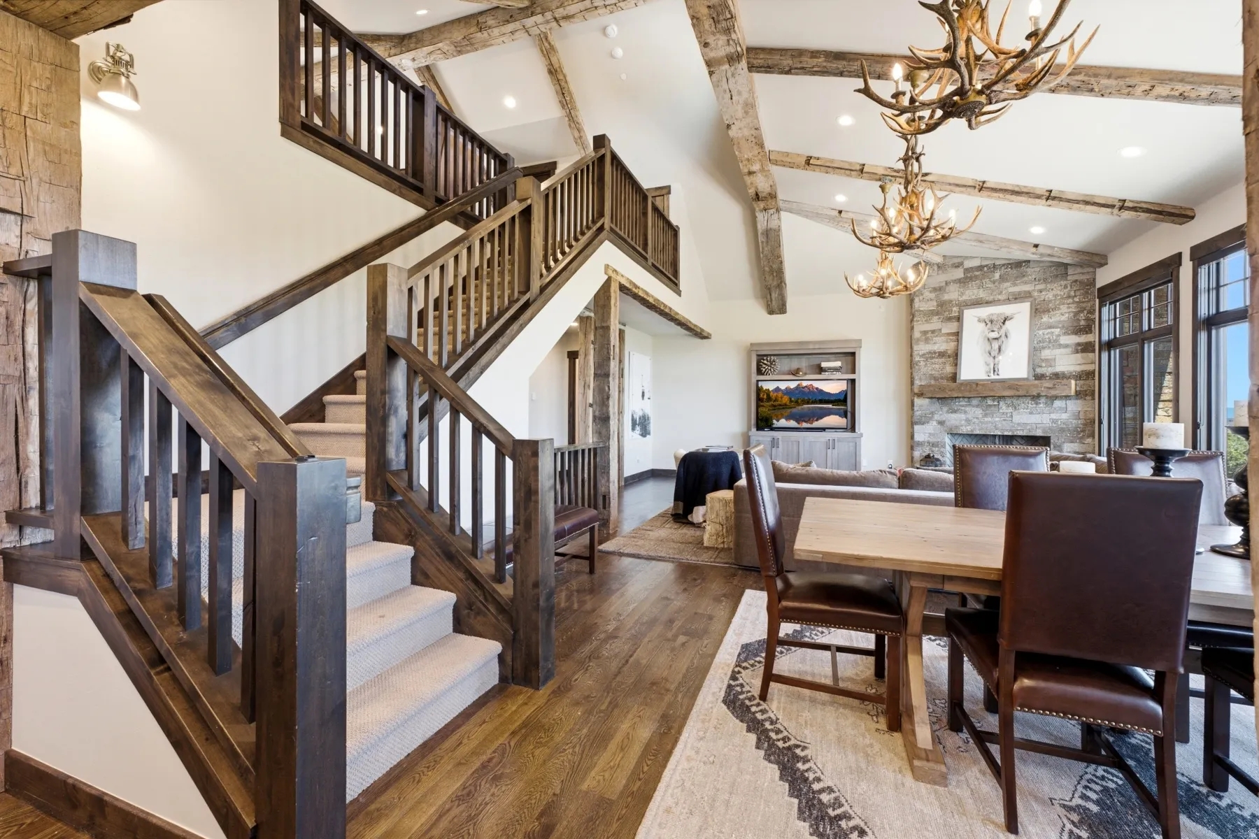 Grand staircase featuring wood-finish railings and carpeted treads