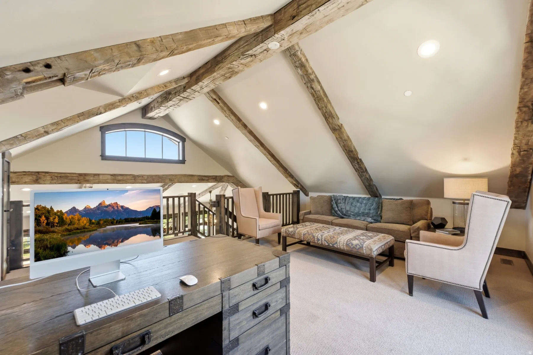 Vaulted ceiling with exposed wood beams, recessed lighting, and an arched window