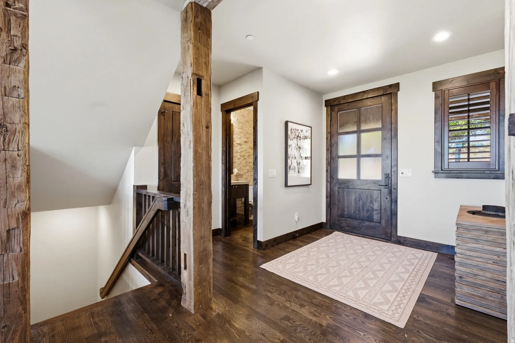 Wood-finish flooring throughout, featuring prominent exposed wood beams and matching dark wood trim