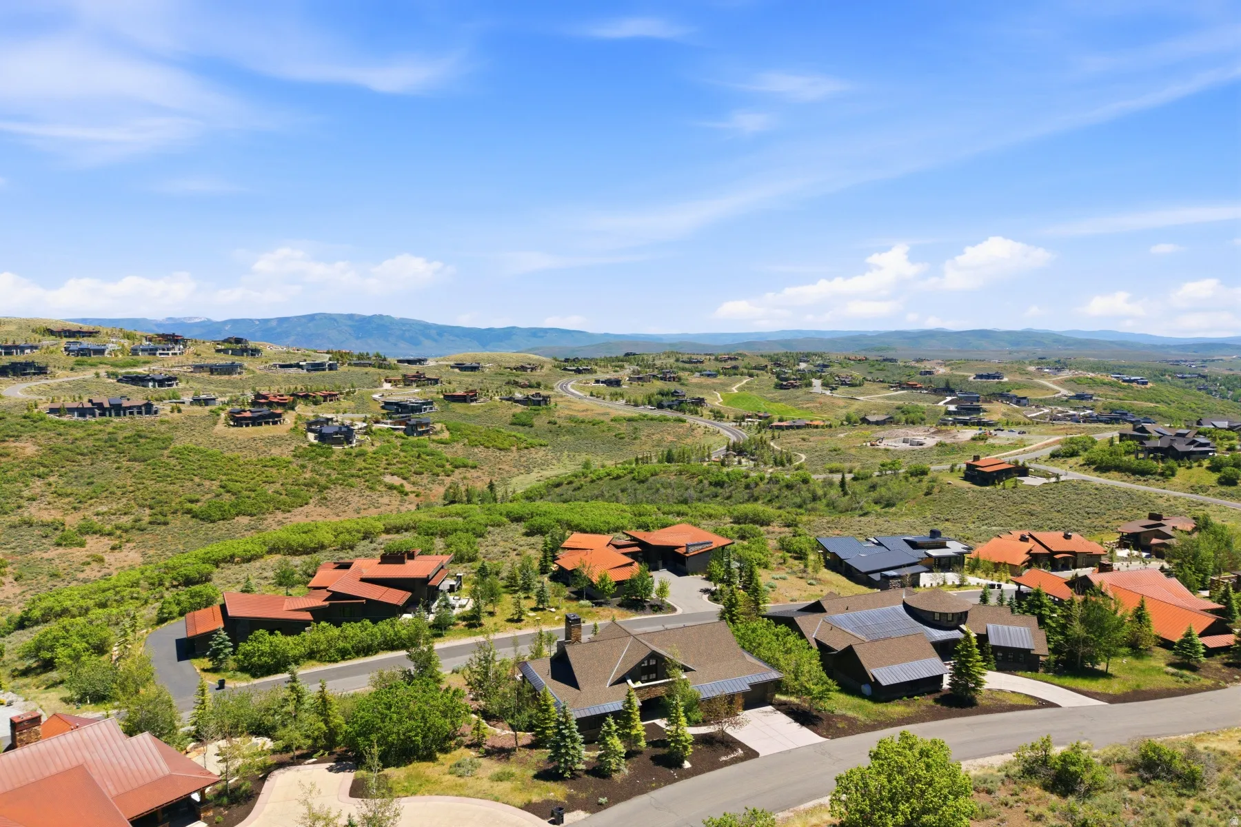 Expansive mountain landscape featuring varied architectural styles and mature natural landscaping