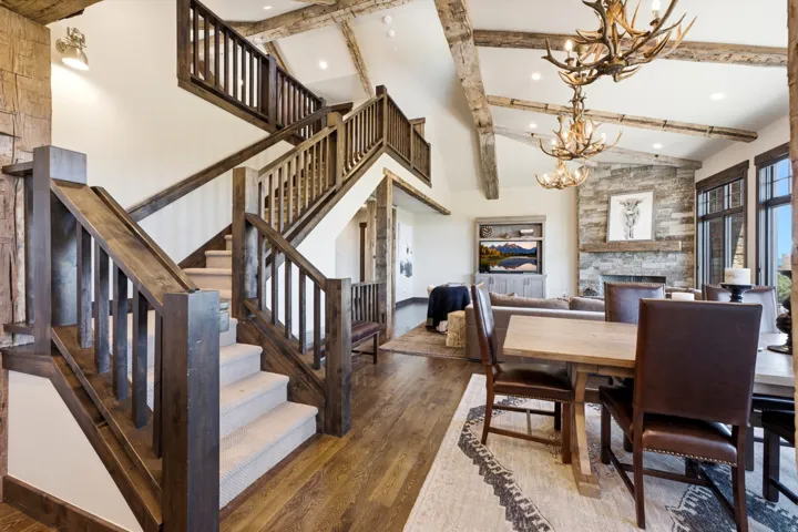 Grand staircase featuring wood-finish railings and carpeted treads