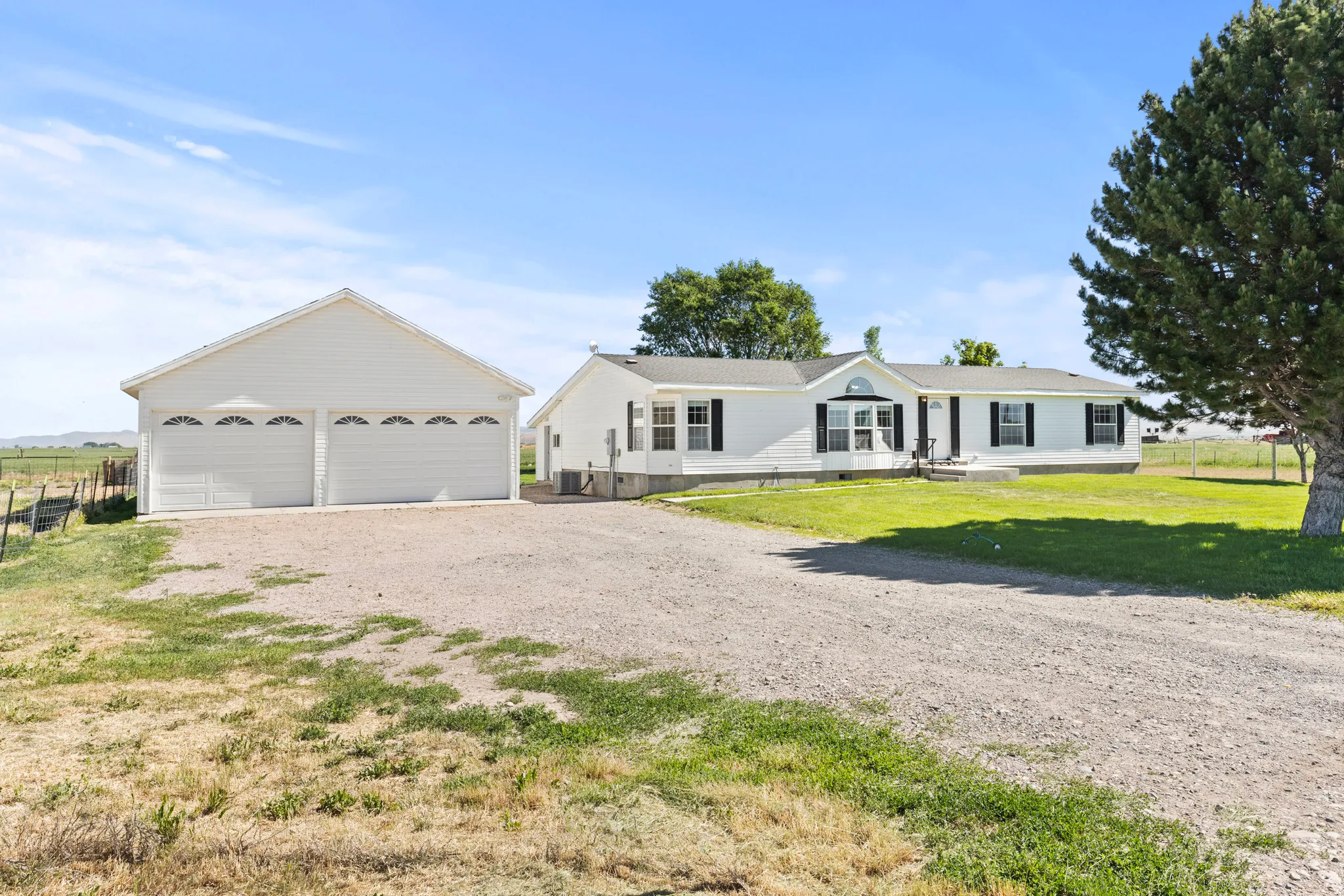 White siding residence featuring a detached two-car garage with decorative windows