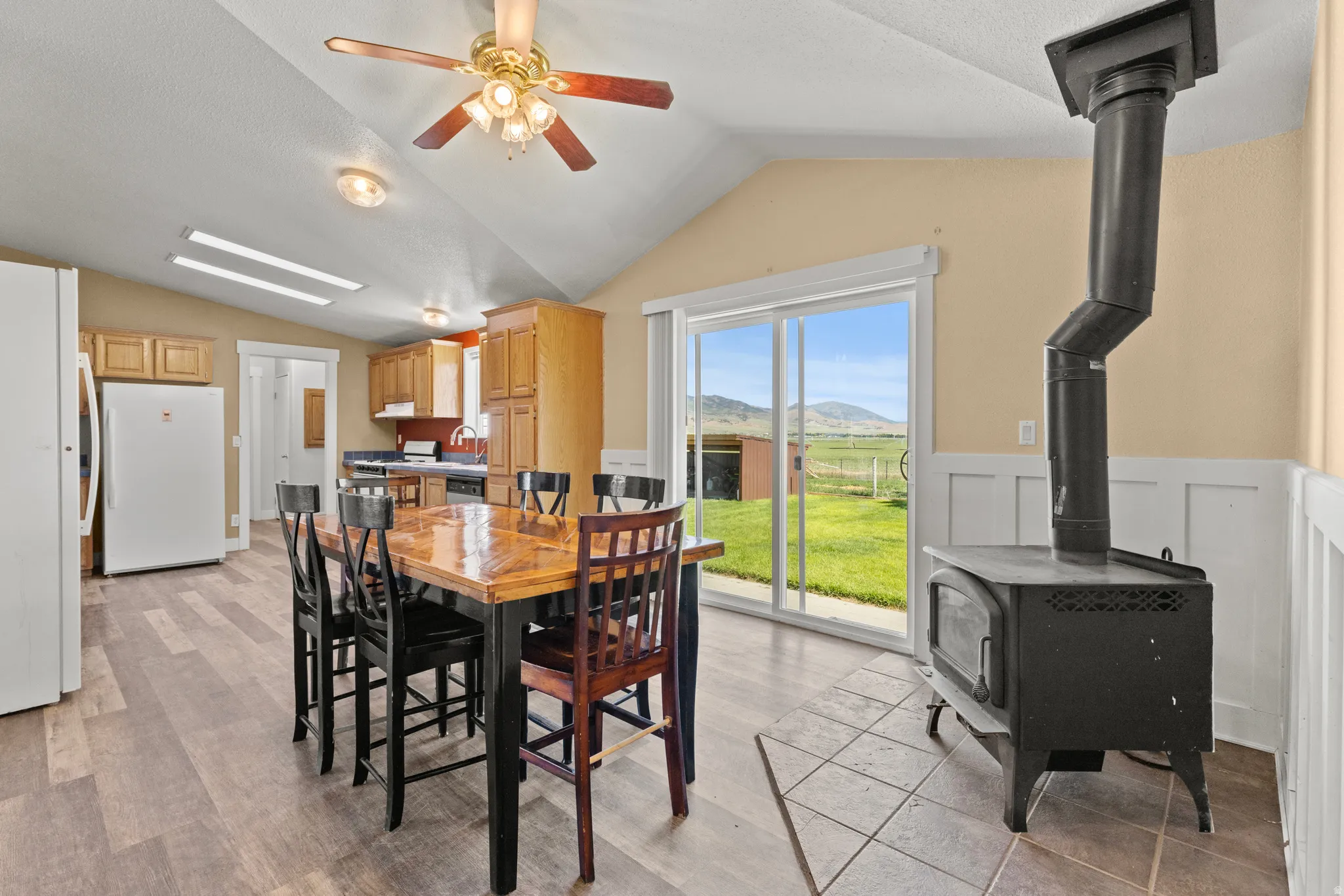 Open-concept living area featuring a vaulted ceiling and wood-finish flooring