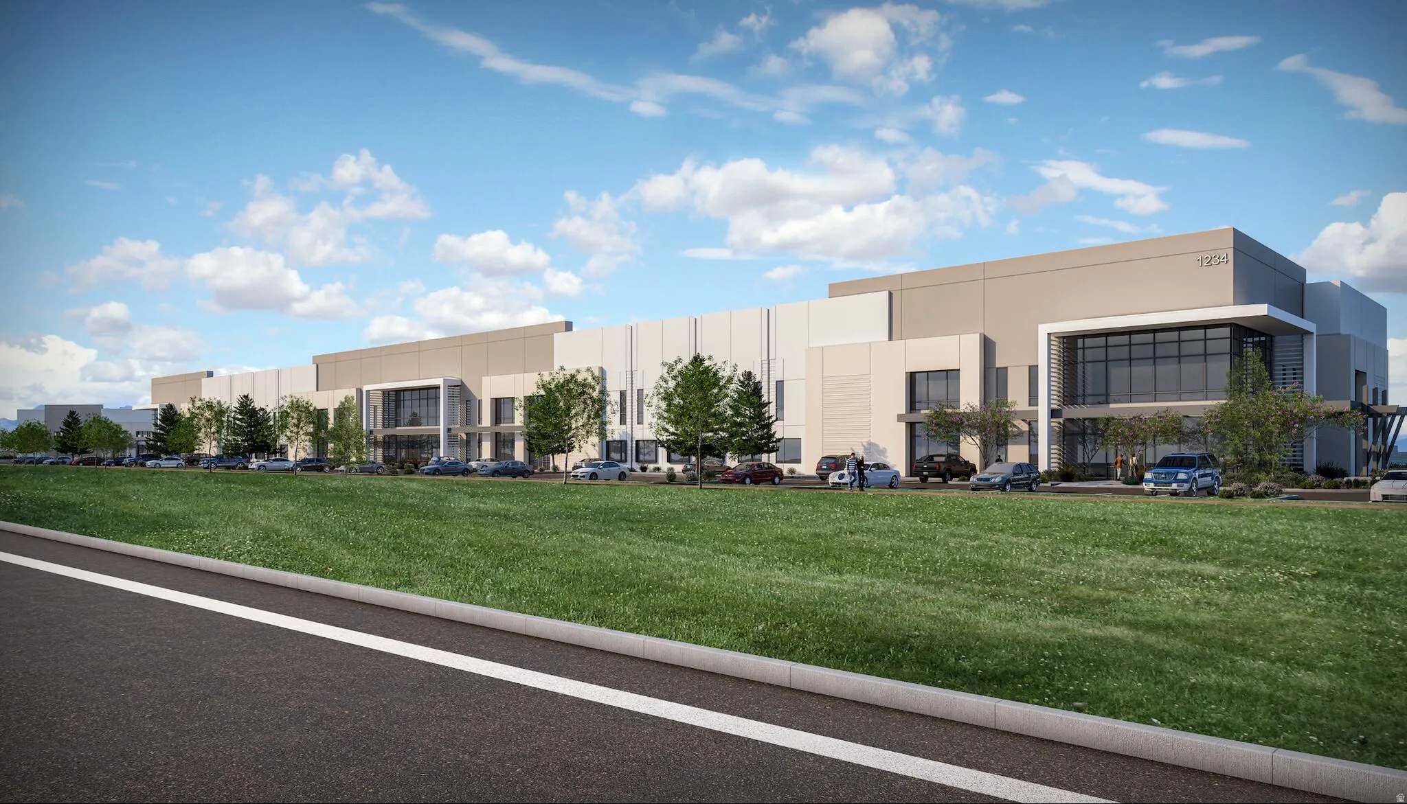 Modern industrial building featuring expansive exterior walls, a prominent glass-fronted entrance, and ample on-site parking
