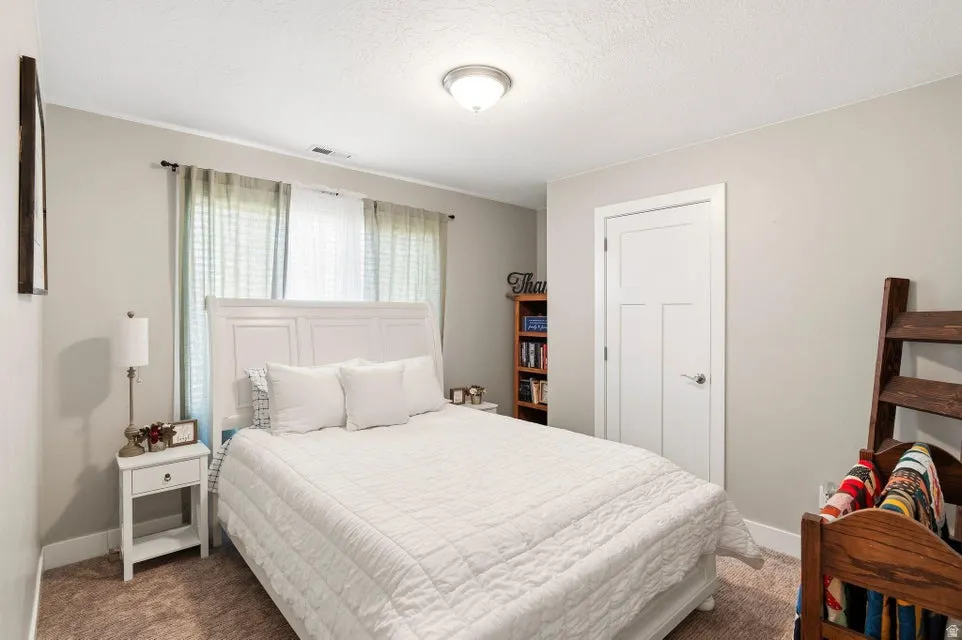 Inviting bedroom featuring neutral wall tones and plush carpeting
