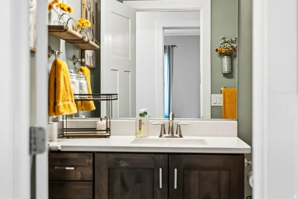 Bathroom vanity featuring a quartz countertop with an integrated sink and brushed nickel faucet
