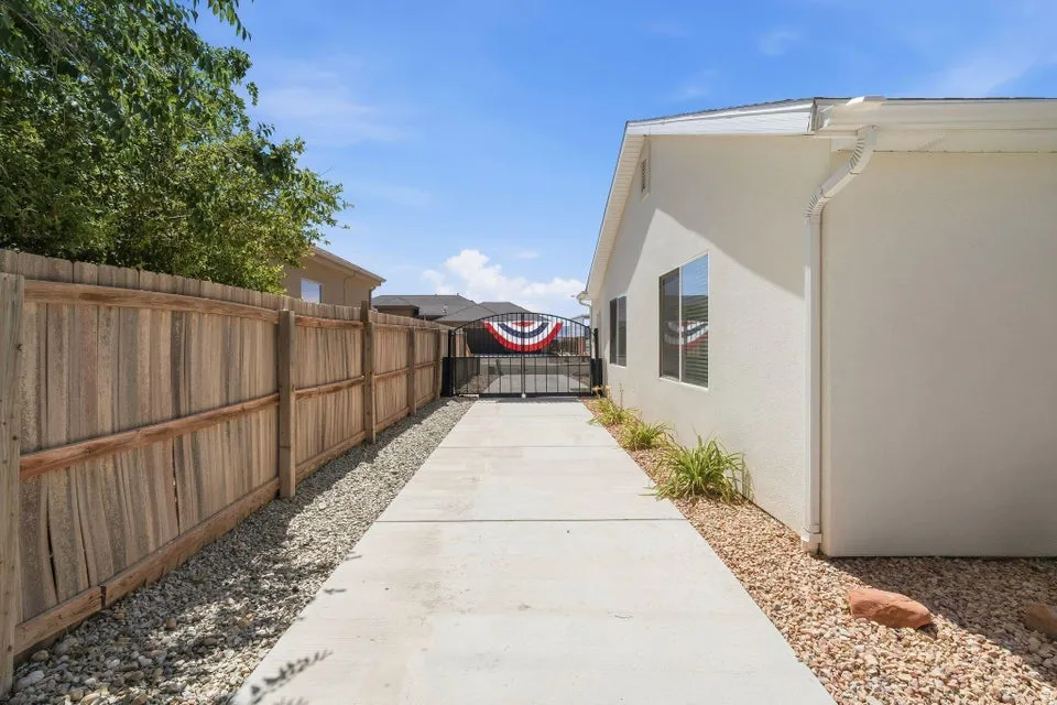 Paved walkway with a wood fence and stucco exterior