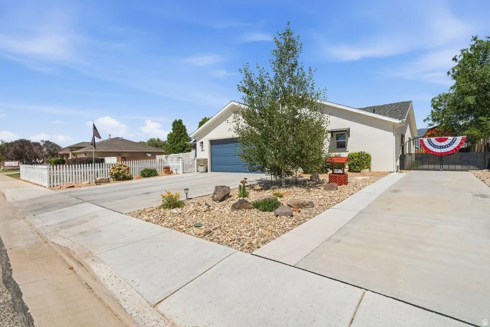 Exterior featuring a smooth stucco finish, a dark blue garage door, and a pitched roofline
