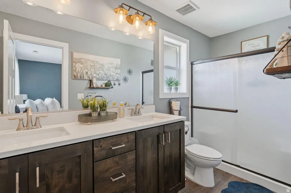 Dual basin vanity featuring quartz countertops and wood-finish cabinetry