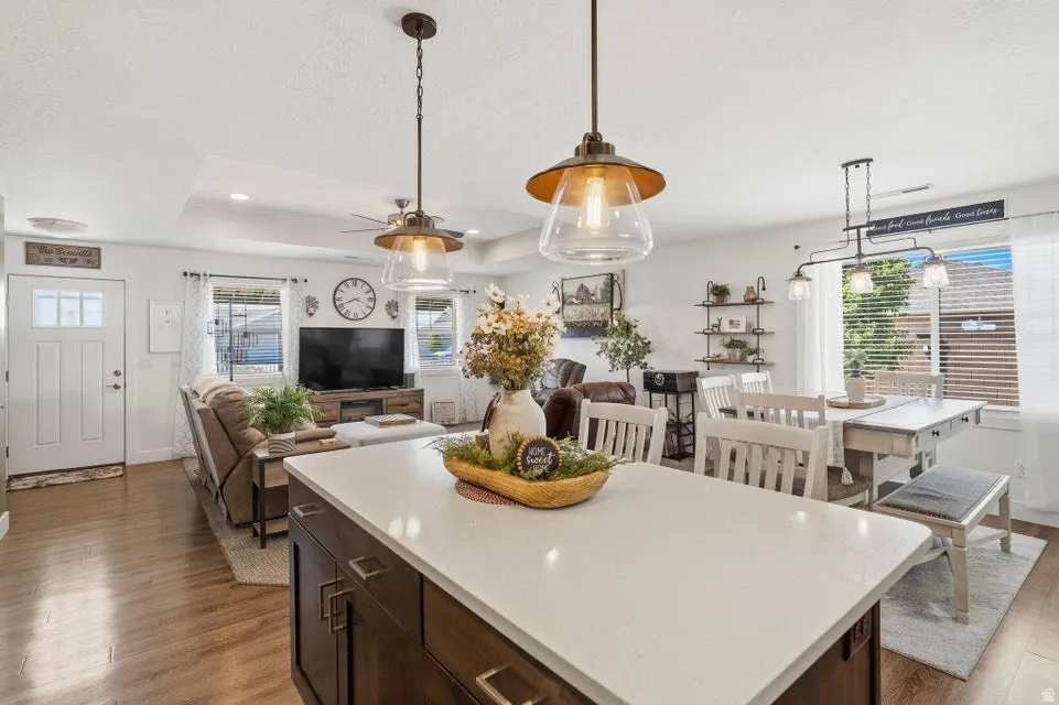 Central kitchen island featuring a light-toned countertop and rich wood-finish cabinetry